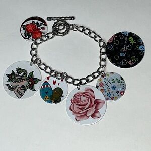 NWOT lightweight metal bracelet w/6 metal cool disc charms.Bracelet is approx 8”